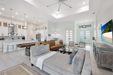 Living room with ceiling fan, a tray ceiling, and