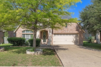 View of front facade featuring driveway, brick si