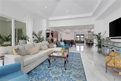 Living area featuring a chandelier, light marble finish flooring, and recessed lighting