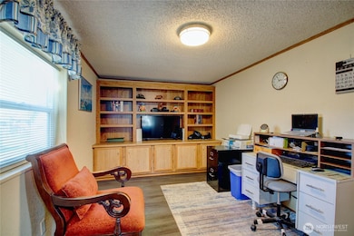 Left of the entry is a room that is currently used as an office and has built-in cabinet with shelves.
