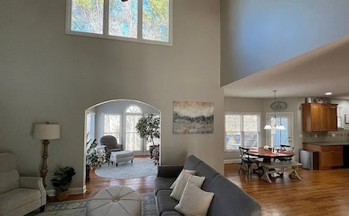 Living room with arched walkways, a high ceiling, 