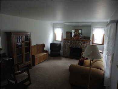 Living Room. Stone fireplace, neutral carpet, and 