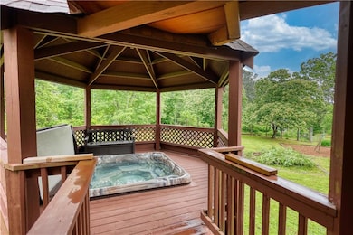Wooden deck featuring a gazebo and view of wooded area