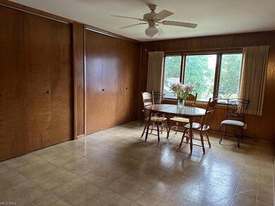 Tiled dining space with wooden walls and ceiling fan