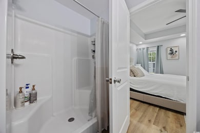 Ensuite bathroom featuring wood finished floors, e