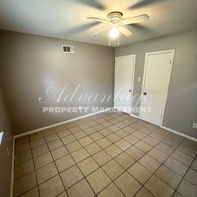 Tiled spare room featuring ceiling fan and a textu