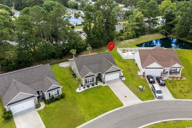 Aerial view of property and surrounding area with a nearby body of water