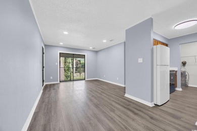 Unfurnished living room with light wood finished floors, recessed lighting, and a textured ceiling