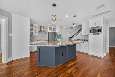 This modern kitchen features a large granite islan