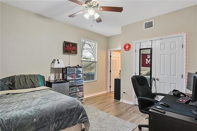 Bedroom featuring a closet, a ceiling fan, wood fi