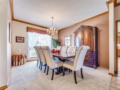 Dining room with a chandelier, ornamental molding, and light colored carpet