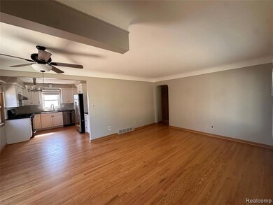 Unfurnished living room with light wood-style flooring, arched walkways, and ceiling fan