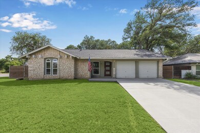 Ranch-style home with driveway, a front yard, a g