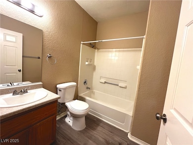 Full bathroom with a textured wall, wood finished