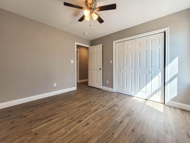 Unfurnished bedroom featuring wood finished floors, a ceiling fan, and a closet