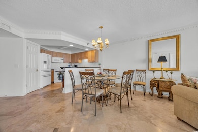 Dining room with a textured ceiling, a chandelier, and baseboards