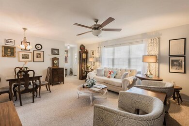 Living/ Dining area with light carpet and a ceilin