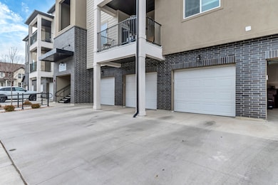 View of apartment building / complex with a garage and driveway