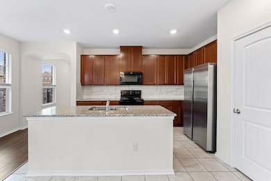 Kitchen with black appliances, decorative backspl