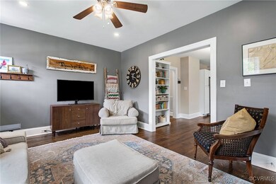 Living room featuring ceiling fan and dark hardwoo