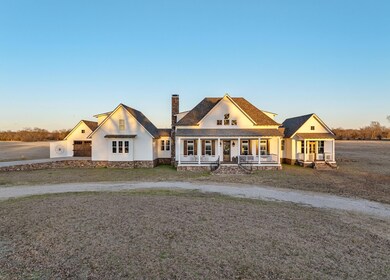 View of front of home with curved driveway, a porc