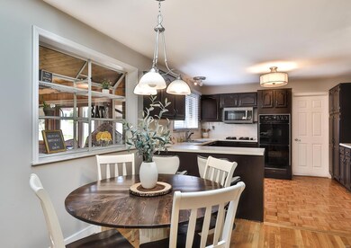 Appealing Breakfast Room exhibits a pendant light, sky light, green house window and secretary with storage cabinets and under cabinet lighting.