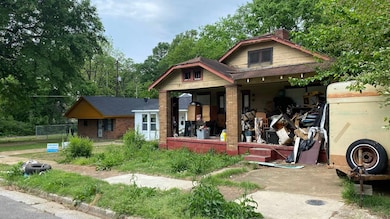 View of front of property with a chimney, brick siding, a porch, and a gambrel roof