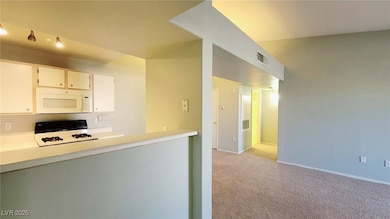 Kitchen featuring white microwave, gas range oven,