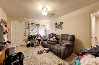 Tiled living room with a textured ceiling