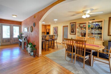 Double door with leaded glass and entry foyer, wood floors, dining room and breakfast bar.