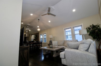 Living room featuring ceiling fan, vaulted ceiling