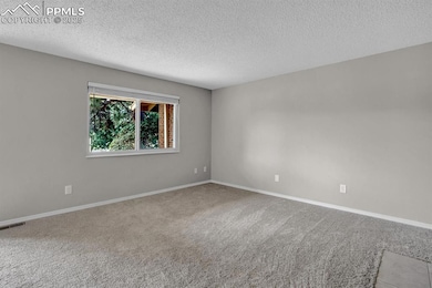 Unfurnished room featuring a textured ceiling, car