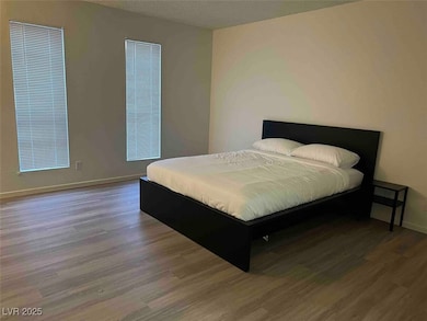 Bedroom featuring wood finished floors and baseboa