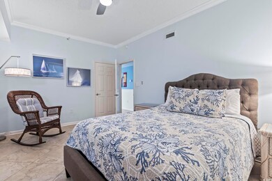 Tiled bedroom featuring ceiling fan and ornamental molding