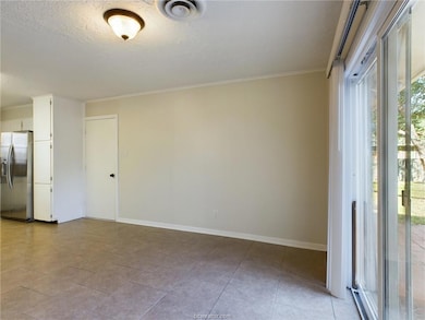 Spare room featuring crown molding and light tile patterned flooring