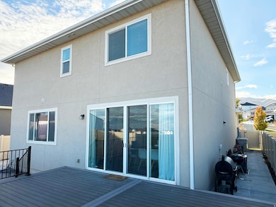 Rear view of house with stucco siding and a deck