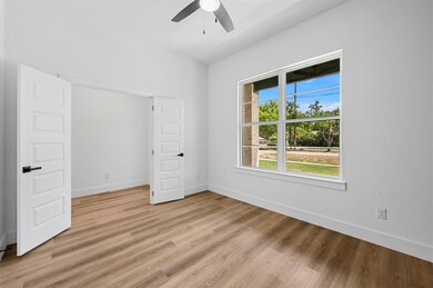Empty room featuring ceiling fan and light wood-ty