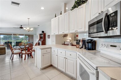 Kitchen featuring stainless steel microwave, white