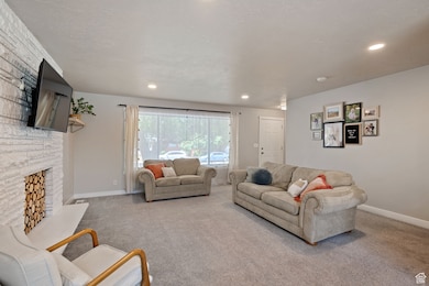 Carpeted living room featuring a fireplace and recessed lighting