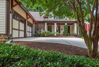 View of front of house featuring driveway, a porch, roof with shingles, and a garage
