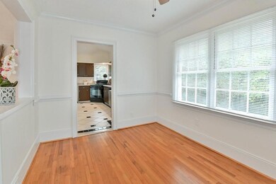 Empty room with light wood-style floors, ceiling fan, and crown molding