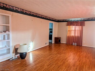 Unfurnished room featuring built in shelves and hardwood / wood-style flooring