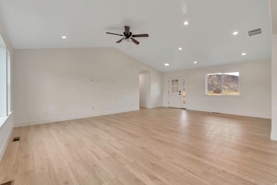 Unfurnished living room featuring light wood-style floors, recessed lighting, vaulted ceiling, and a ceiling fan