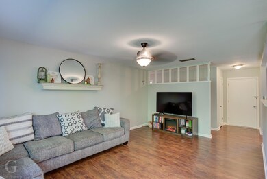 Living room featuring ceiling fan and dark hardwoo