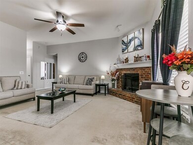 Living area featuring carpet, a brick fireplace, a