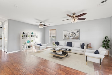 Living room with ceiling fan and dark hardwood / w