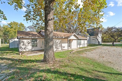 View of front of home featuring a front yard, a garage, and roof with shingles
