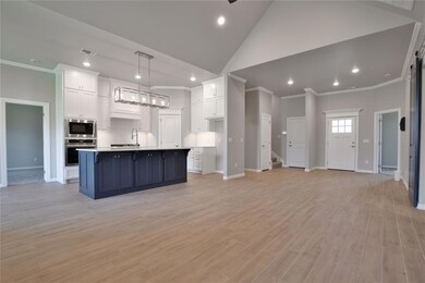 Kitchen featuring hanging light fixtures, white ca
