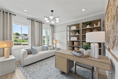 Living area with a chandelier, wood finished floors, and ornamental molding
