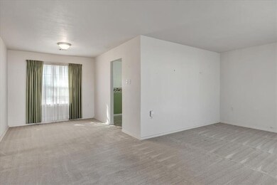 living and dining room featuring light carpet